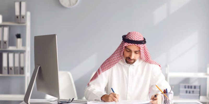 Calm arab man sits at a table in the office. Arab business people concept.